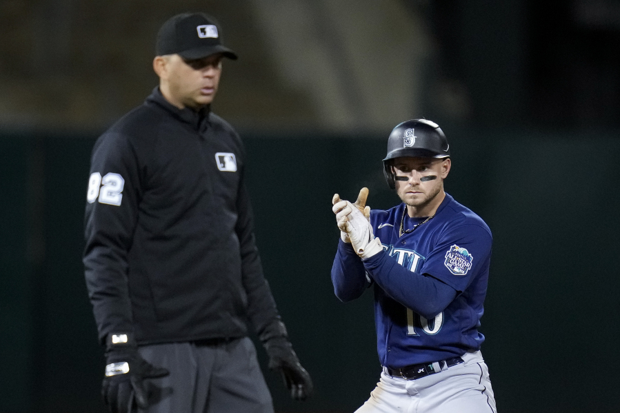 Seattle Mariners' Jarred Kelenic, right, celebrates after hitting an RBI double against the Oakland Athletics during the eighth inning of a baseball game in Oakland, Calif., Tuesday, May 2, 2023. (AP Photo/Godofredo A.