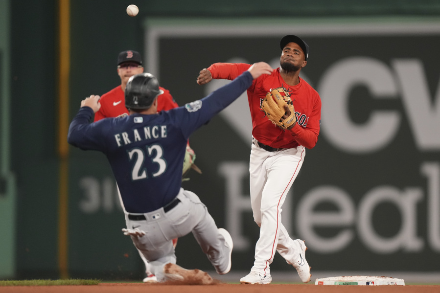 Boston Red Sox's Pablo Reyes, right, throws to first as Seattle Mariners' Ty France (23) slides out at second base in the sixth inning of a baseball game Wednesday, May 17, 2023, in Boston.