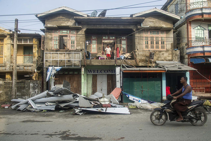 A local rides motorbike past damaged buildings after Cyclone Mocha in Sittwe township, Rakhine State, Myanmar, Monday, May 15, 2023. Rescuers on Monday evacuated about 1,000 people trapped by seawater 3.6 meters (12 feet) deep along western Myanmar's coast after the powerful cyclone injured hundreds and cut off communications.