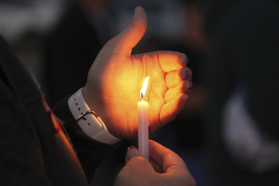 A community member holds a candle during a prayer vigil at Hills Church, Monday, May 15, 2023, in Farmington, N.M. Authorities said an 18-year-old man roamed through the community firing randomly at cars and houses Monday, killing three people and injuring six others including two police officers before he was killed.