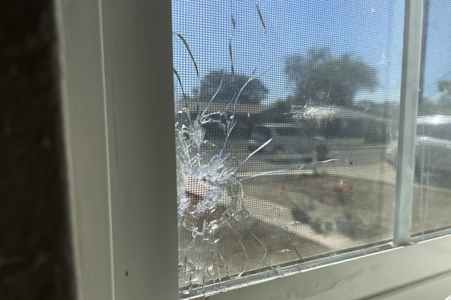 A bullet hole is seen through the bedroom window of Jolene Robledo's home Tuesday, May 16, 2023, in Farmington, N.M. It was among the damage resulting from a deadly shooting along a residential street in the northwestern New Mexico community.