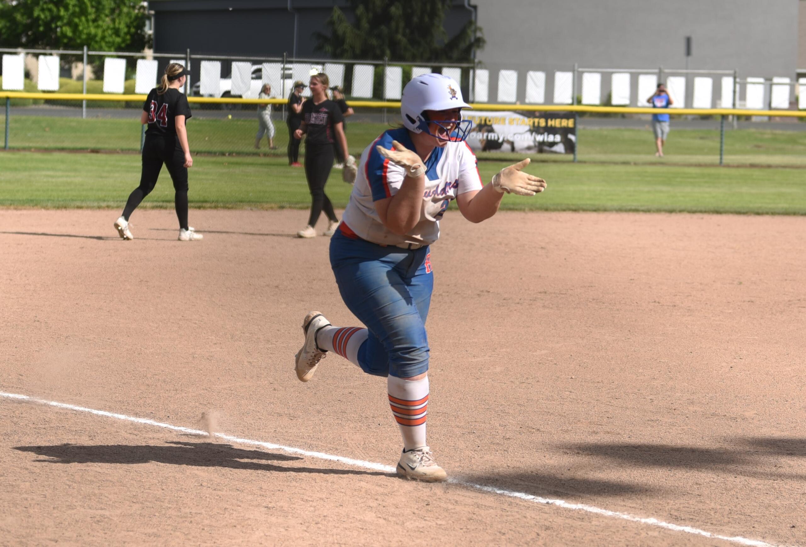 Ridgefield's Maizy Whitlow celebrates her grand slam as she approaches home plate in the third inning of a 21-3 win over Cedarcrest in the quarterfinals of the 2A state softball tournament Friday in Selah.