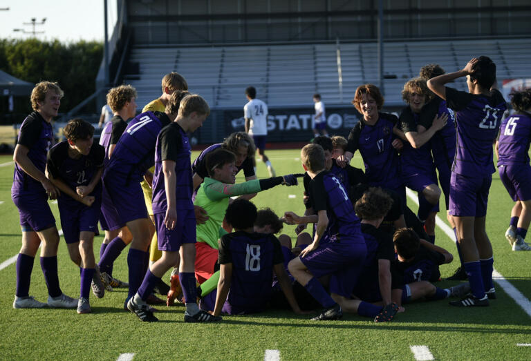 Columbia River boys soccer players make a dogpile in the middle of the field after beating North Kitsap 4-2 in the Class 2A state championship match at Renton Memorial Staadium on Saturday, May 27, 2023.