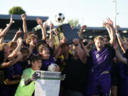Head coach Matt Newman hoists the championship trophy as the Columbia River boys soccer team celebrates its 2A state championship after a 4-2 win over North Kitsap at Renton Memorial Stadium on Saturday, May 27, 2023.