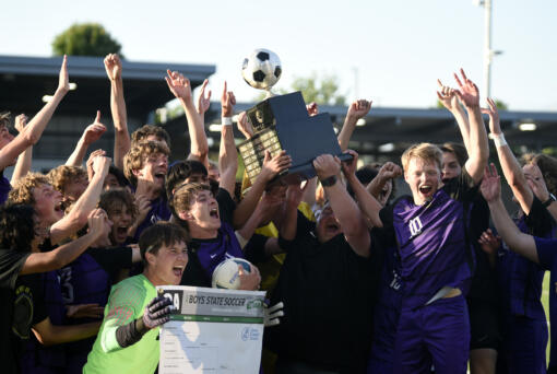 Head coach Matt Newman hoists the championship trophy as the Columbia River boys soccer team celebrates its 2A state championship after a 4-2 win over North Kitsap at Renton Memorial Stadium on Saturday, May 27, 2023.