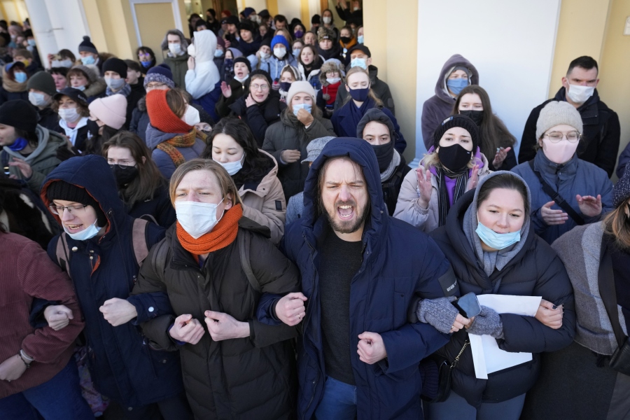 FILE - Demonstrators stand together, holding hands, at a demonstration in St. Petersburg, Russia, Sunday, Feb. 27, 2022. It's becoming increasingly difficult for Russians to escape government scrutiny. Activists say Putin's government has managed to harness digital technology to surveil, censor and control Russians -- new territory in a nation with a long history of spying on its citizens.