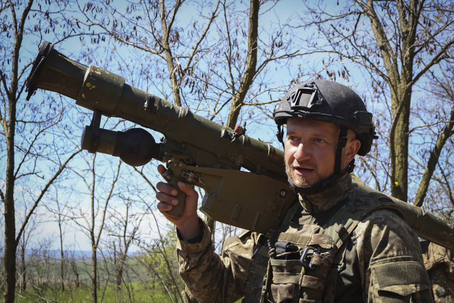 A Ukrainian soldiers carries an "Igla" rocket launcher to his position near Bakhmut in the Donetsk region, Ukraine, Thursday, May 4, 2023.