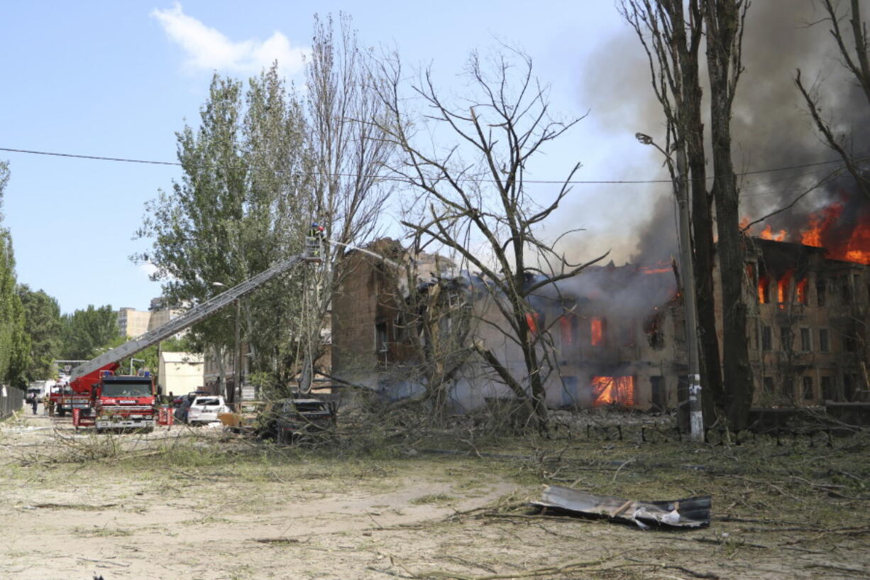 In this handout photo made available by the State Emergency Service of Ukraine, firefighters work next to a destroyed Policlinic following a Russian attack in Dnipro, Ukraine, Friday May 26, 2023.