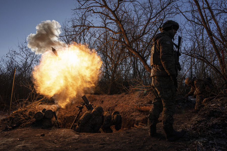 FILE - Ukrainian servicemen fire a 120mm mortar towards Russian positions at the frontline near Bakhmut, Donetsk region, Ukraine, Wednesday, Jan. 11, 2023. Ukrainian President Volodymyr Zelenskyy said Sunday, May 21, 2023 that Russian forces weren't occupying Bakhmut, casting doubt on Moscow's insistence that the eastern Ukrainian city had fallen. The fog of war made it impossible to confirm the situation on the ground in the invasion's longest battle, and the comments from Ukrainian and Russian officials added confusion to the matter.