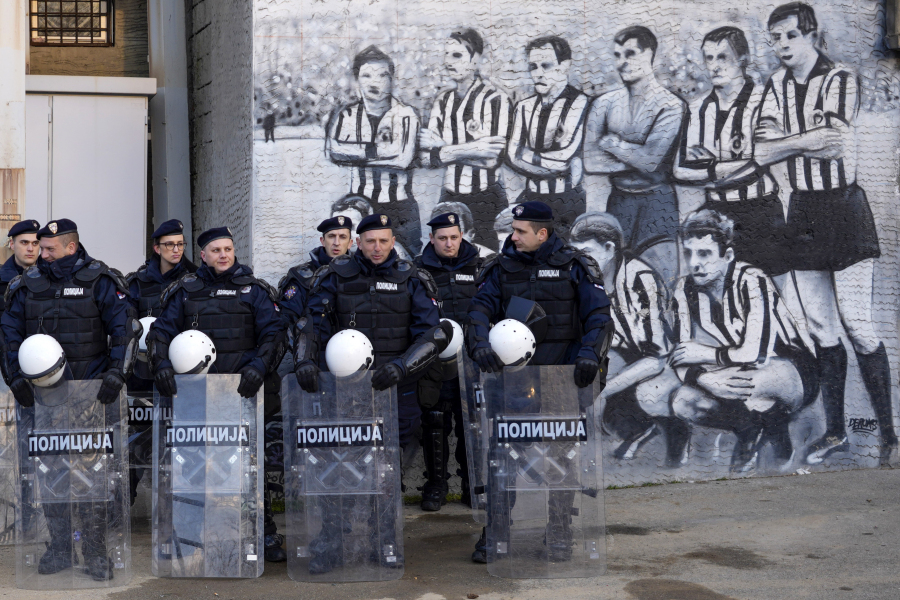 FILE - Serbian police officers guard Partizan stadium prior the Europa Conference League soccer match between Partizan and Feyenoord, in Belgrade, Serbia, on March 10, 2002. In the 90's, poverty surged, crime flourished and mafia-style killings flooded the streets. Inflation was the highest ever in the world, ordinary people lost their savings and jobs, while crime bosses and soccer hooligans rose to prominence.