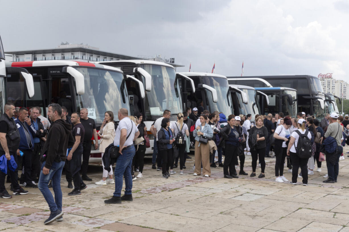 Supporters of Serbian president Aleksandar Vucic are seen as they stand next to buses in Belgrade, Serbia, Friday, May 26, 2023. Tens of thousands of people are expected in the Serbian capital on Friday for a major rally in support of Vucic, who is facing an unprecedented revolt against his autocratic rule amid the crisis triggered by two mass shootings that stunned the nation.