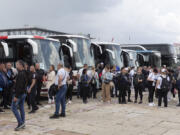 Supporters of Serbian president Aleksandar Vucic are seen as they stand next to buses in Belgrade, Serbia, Friday, May 26, 2023. Tens of thousands of people are expected in the Serbian capital on Friday for a major rally in support of Vucic, who is facing an unprecedented revolt against his autocratic rule amid the crisis triggered by two mass shootings that stunned the nation.