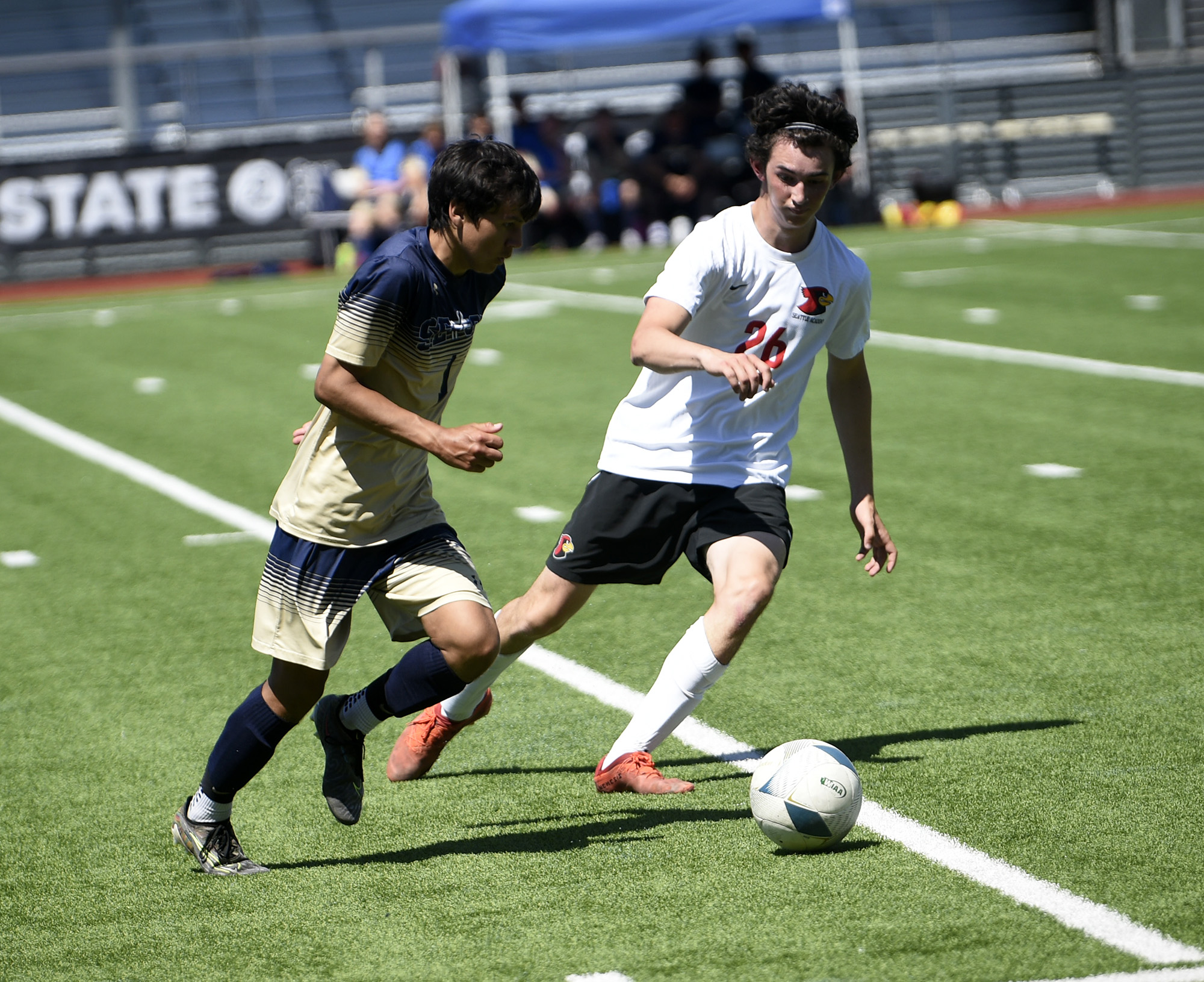 Sam Soto of Seton Catholic (left) dribbles the ball past Seattle Academy's Ben Cady during Seton Catholic's 4-0 loss to Seattle Academy in the 1A boys soccer state semifinal at Renton Memorial Stadium on Friday, May 26, 2023.