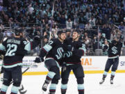 Seattle Kraken center Yanni Gourde (37) celebrates his goal against the Dallas Stars with Oliver Bjorkstrand (22) and Eeli Tolvanen (20) during the first period of Game 6 of an NHL hockey Stanley Cup second-round playoff series Saturday, May 13, 2023, in Seattle.