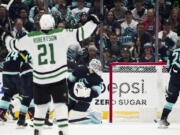 Seattle Kraken goaltender Philipp Grubauer (31) looks back at a goal by Dallas Stars' Jamie Benn, not seen, as Stars left wing Jason Robertson (21) celebrates during the first period of Game 4 of an NHL hockey Stanley Cup second-round playoff series Tuesday, May 9, 2023, in Seattle.