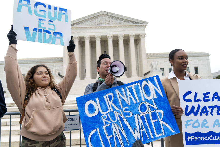 FILE - Bethsaida Sigaran, left, of Baltimore, her brother Jaime Sigaran, with American Rivers, and Thea Louis, with Clean Water Action, join supporters of the Clean Water Act as they demonstrate outside the Supreme Court, Monday, Oct. 3, 2022, in Washington, as the court begins arguments in Sackett v. Environmental Protection Agency (EPA). The Supreme Court on Thursday, May 25, 2023, made it harder for the federal government to police water pollution in a decision that strips protections from wetlands that are isolated from larger bodies of water.
