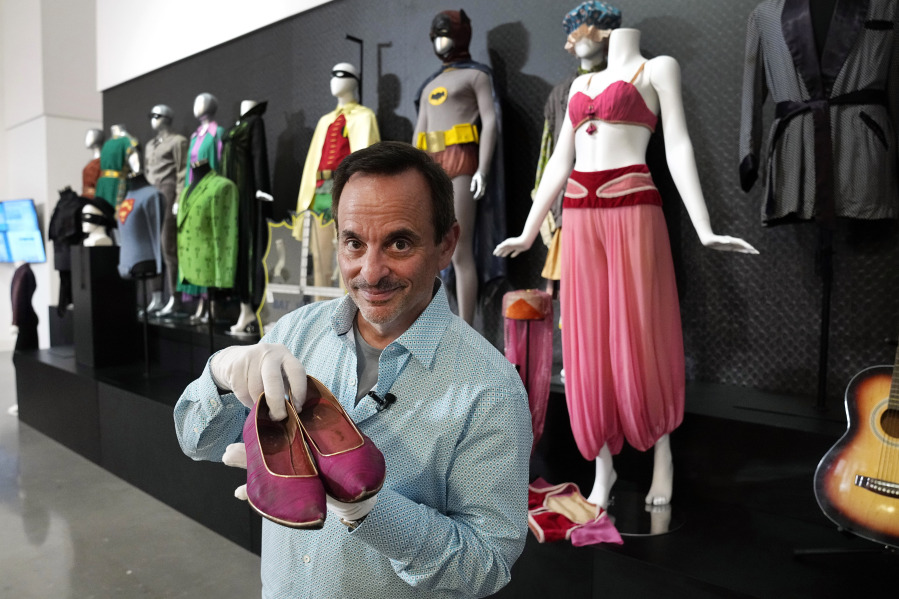 James Comisar holds a pair of shoes once used by actor Barbara Eden in the television show, "I Dream of Jeannie", Thursday, April 27, 2023, in Irving, Texas. A dizzying number of props, sets, and costumes from television shows beloved by generations of viewers will be sold at auction next month. The collection James Comisar has spent over 30 years amassing includes "The Tonight Show" set Johnny Carson gave him after retiring, the timeworn living room from "All in the Family," and the bar where Sam Malone served customers on Cheers.