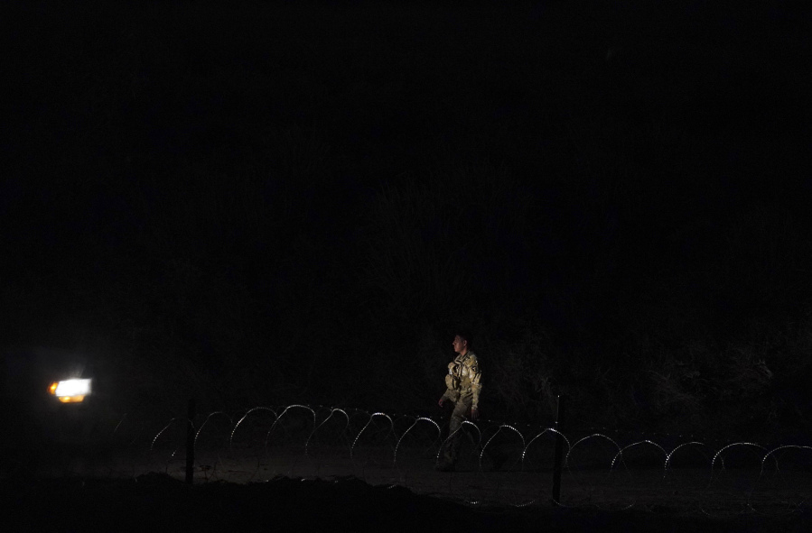 A Texas National Guard member patrols behind razor wire on the bank of the Rio Grande, seen from Matamoros, Mexico, Thursday, May 11, 2023. U.S. authorities have been unveiling strict new measures, which crack down on illegal crossings while also setting up legal pathways for migrants who apply online, seek a sponsor and undergo background checks. If successful, the reforms could fundamentally alter how migrants arrive at the U.S.-Mexico border.