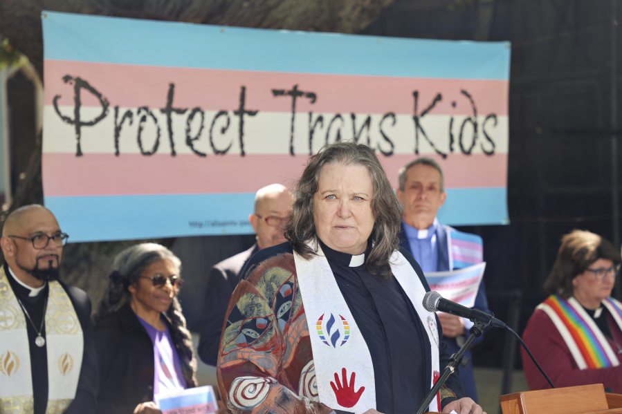 In this photo provided by Dirk Bolle, the Rev. Pat Langlois, senior pastor of MCC Church of Christ of the Valley, speaks at an interfaith rally in Pasadena, Calif., on March 31, 2023, protesting the wave of anti-transgender bills being enacted in numerous Republican-governed states. "These bills are the most vitriolic and cruel legislation I've seen," she said. "I have a non-binary teenager, so I take this really personally, not just as a person of faith and as a lesbian, but as a mom." Langlois, whose LGBTQ activism spans several decades, described the current situation as "probably the scariest time" because of the array of hostile bills.