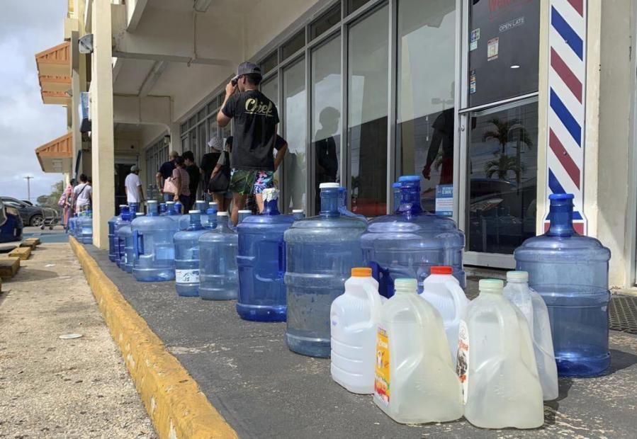 Numerous containers line the sidewalk outside the Wellness Water & Ice store in Yigo, Guam, as island residents make preparations for possible inclement weather on Sunday, May 21, 2023. Guam's governor is urging residents to stay home and is warning the island could take a direct hit from Typhoon Mawar. The storm is strengthening on its path toward the U.S. territory in the Pacific.