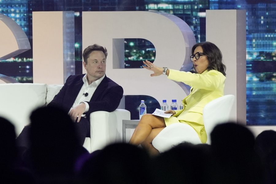 FILE - Twitter CEO Elon Musk, center, speaks with Linda Yaccarino, chairman of global advertising and partnerships for NBC, at the POSSIBLE marketing conference, Tuesday, April 18, 2023, in Miami Beach, Fla. Musk announced Friday, May 12, 2023, that he's hiring Yaccarino to be the new CEO of San Francisco-based Twitter, which is now called X Corp.