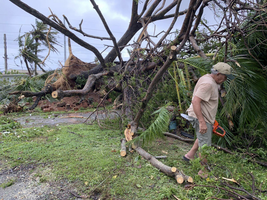 Andy Villagomez clears what remains of a large tree that overshadowed his front yard before falling to Typhoon Mawar, Thursday, May 25, 2023, in Mongmong-Toto-Maite, Guam.