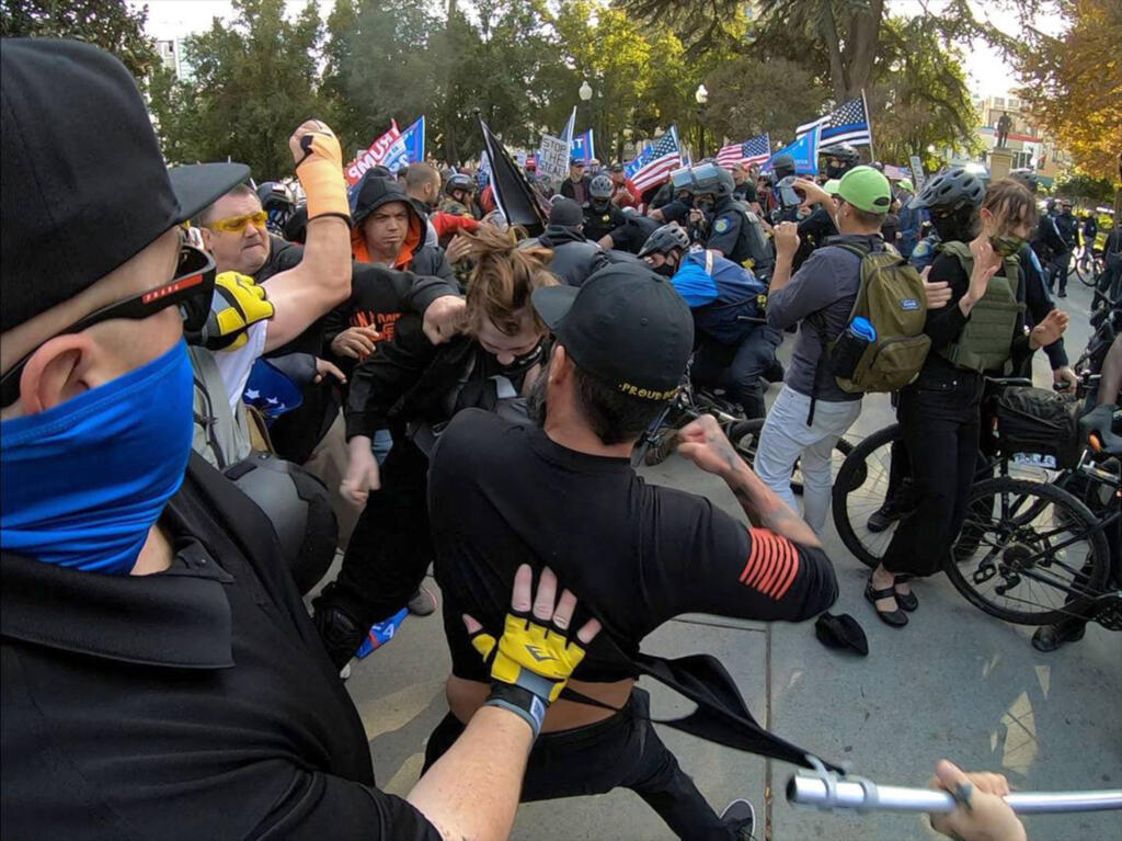 Members of the Proud Boys brawl with counter-protesters at Cesar Chavez Plaza in Sacramento, California after a Trump rally on Saturday, Nov. 21, 2020.