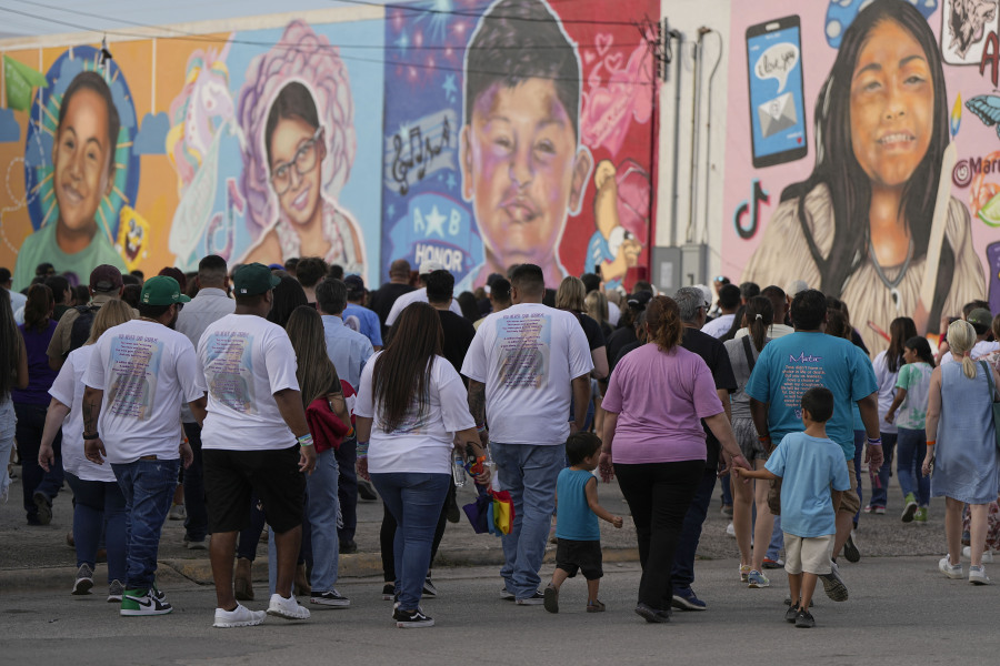 Family member make a mural walk before a candlelight vigil in Uvalde, Texas, Wednesday, May 24, 2023. One year ago a gunman killed 19 children and two teachers inside a fourth-grade classroom.
