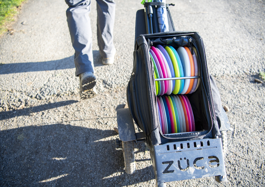 Josh Dearing wheels a bag of disc golf discs around at Hockinson Meadows Community Park.