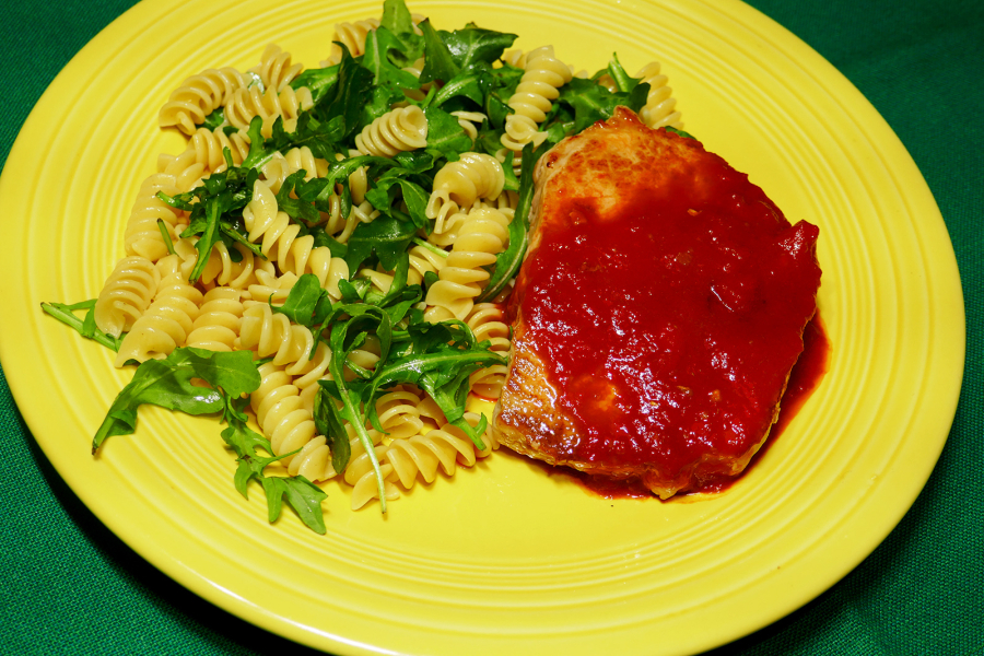 Skillet pork chops with sweet red pepper sauce with rotini and arugula.