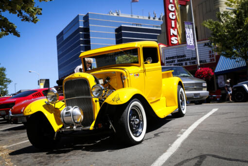 Pamela Lund peeks inside a 1931 Ford pickup during the Cruise the Couve event held on Main Street in Vancouver in 2019. (The Columbian files)