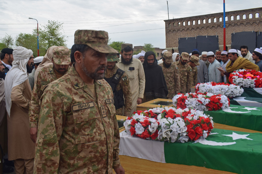 Relatives and security officials gather around the coffins of policemen who were killed by a roadside bomb in Lakki Marwat district of Khyber Pakhtunkhwa province on March 30, 2023.    Four policemen were killed by a roadside bomb as they scrambled to protect a police station under seige by domestic Taliban militants in northwest Pakistan, officials said.
