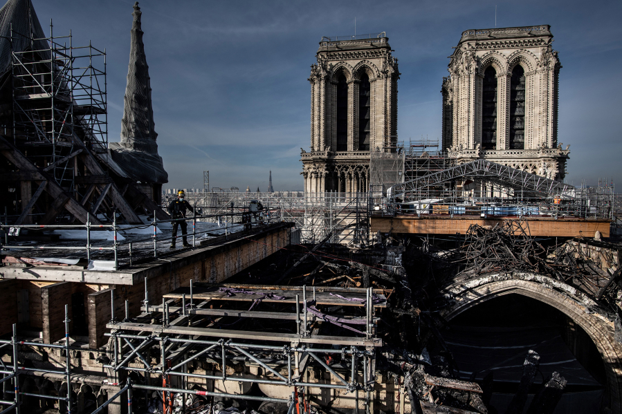 Workers on the roof of Notre Dame work to remove the burnt scaffolding Nov. 24, 2020 which hampered the safety of the cathedral damaged by the April 15, 2019 fire in Paris.