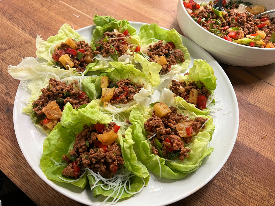 Lettuce wraps filled with ground pork tossed in red curry with pepper and pineapple.