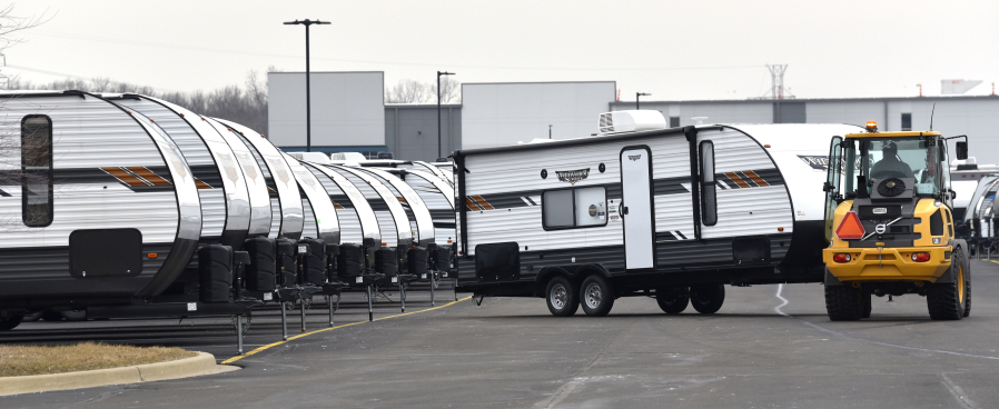 An RV porter moves travel trailers into place as General RV prepares for their sales event as customers prepare for another camping season, in Wixom, Mich., March 15, 2022.