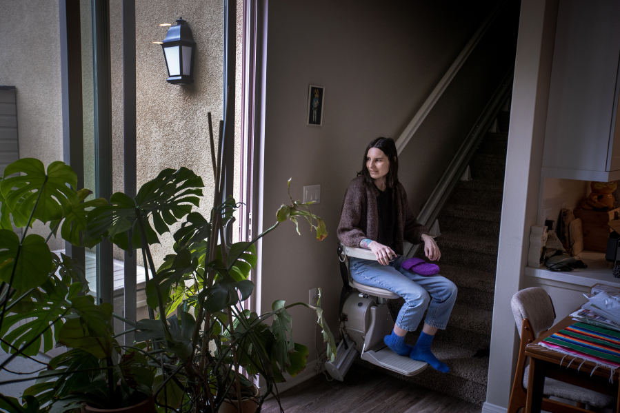 Courtney Gavin, at her Irvine, California home in February 2023, has been dealing with the effects of COVID-19 since March 2020 and uses a motorized lift to climb the stairs. (Allen J.