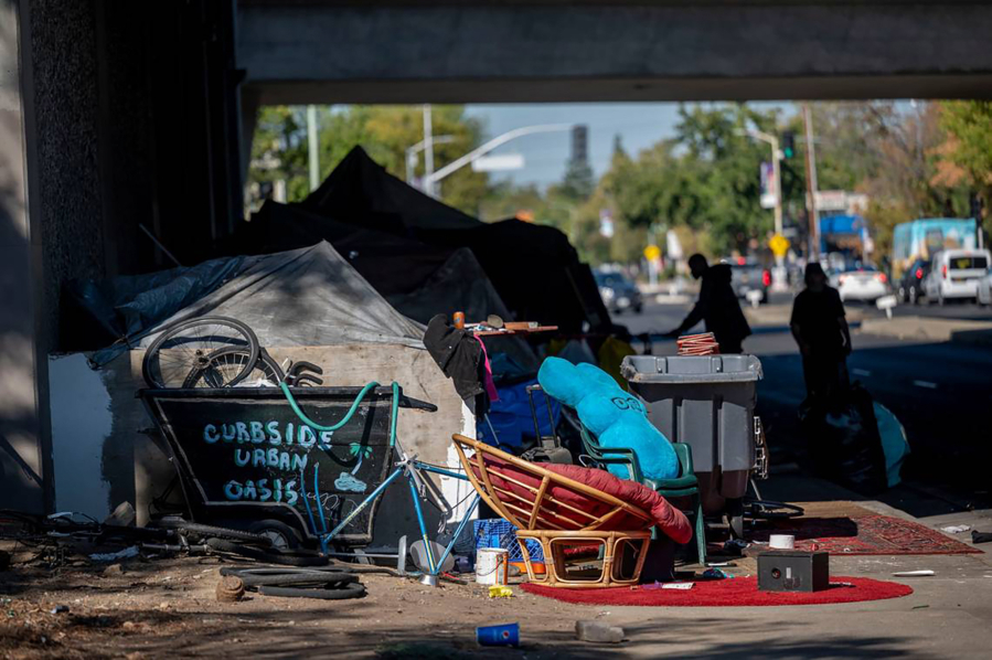 A sign that reads "curbside urban oasis" welcomes people walking on Alhambra Boulevard under the Highway 99 underpass on Oct. 5, 2022, in Sacramento, California.