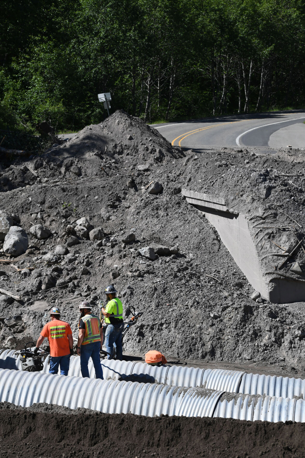 Scarsella Brothers, Inc. employees work to install culverts at the site of the South Coldwater Slide on Spirit Lake Memorial Highway on Thursday.
