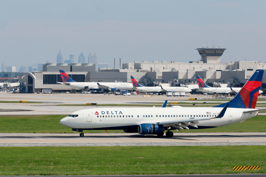 With the Atlanta skyline in the background, a Delta airplane lands at Hartsfield-Jackson Domestic Airport on Sept. 7, 2022, in Atlanta.