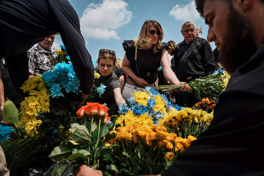 Mourners at Lychakiv cemetery put flowers the color of Ukraine???s flag, yellow and blue, on the grave of Mykhailo Lazarev, who was killed in action.