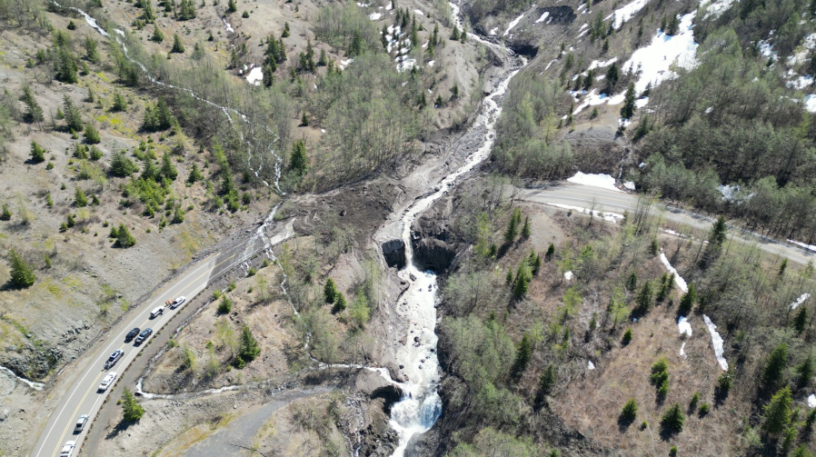 A Washington State Department of Transportation engineering geologist studies the head of the landslide that buried Highway 504 some 2,000 feet below.
