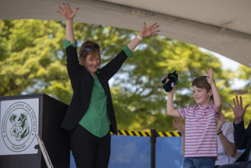 Center for Deaf and Hard of Hearing Youth interim executive director Shauna Bilyeu, left, applauds Washington School for the Deaf first-grader Dexter White, right, who brought a stuffed terrier mascot to put in a time capsule on Thursday during a groundbreaking ceremony for the Center for Deaf and Hard of Hearing Youth at Washington School for the Deaf. The capsule will be buried somewhere on campus and is set to be opened in 2104.