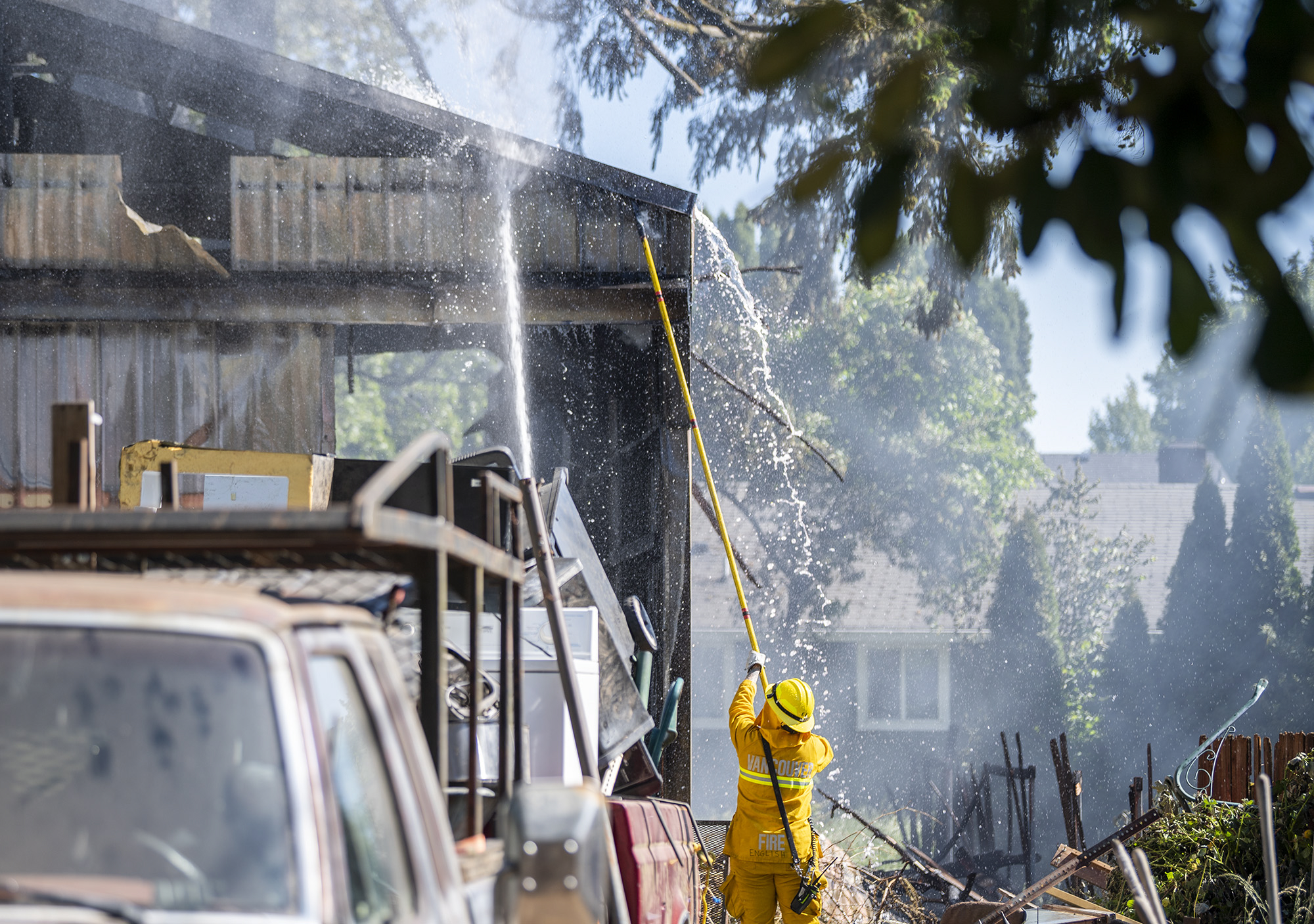 Vancouver firefighters work to put out a hotspot on a burned building Monday, June 5, 2023, on Northeast 68th Avenue in Vancouver.