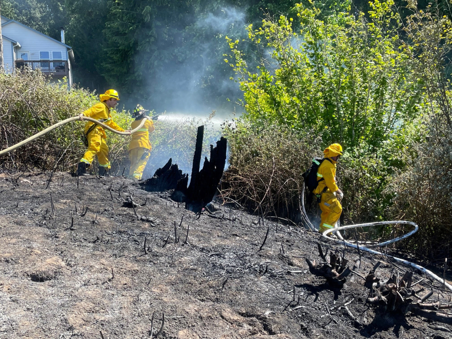 Vancouver firefighters battle a fire that burned in the Burnt Bridge Creek Greenway on Monday, threatening a row of houses atop a bluff overlooking the greenway. While fighters battled that blaze, another fire sparked a few miles away, which also threatened houses.