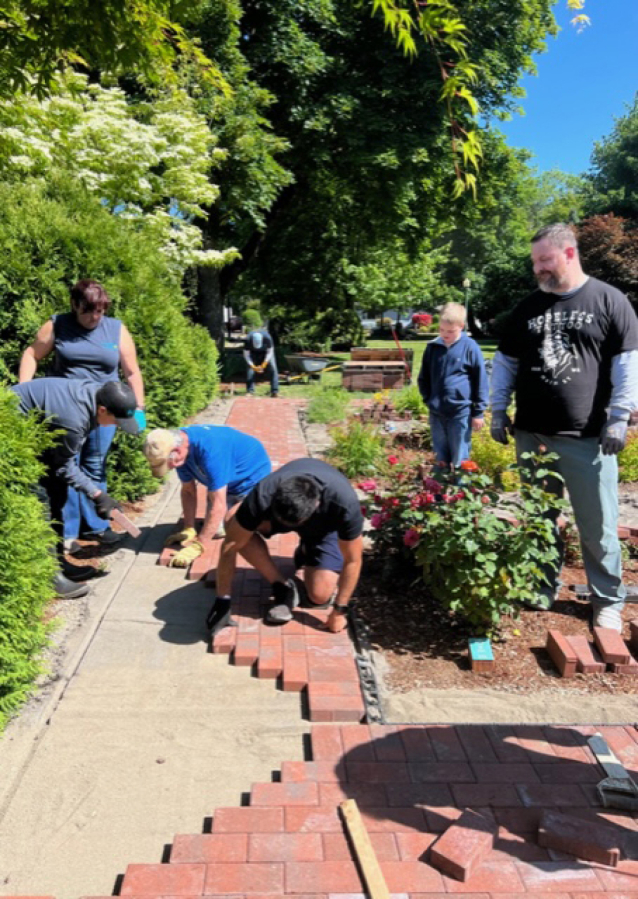 Members and family of the Lewis River Rotary Club recently gathered to install a brick walkway in Battle Ground's Central Park.