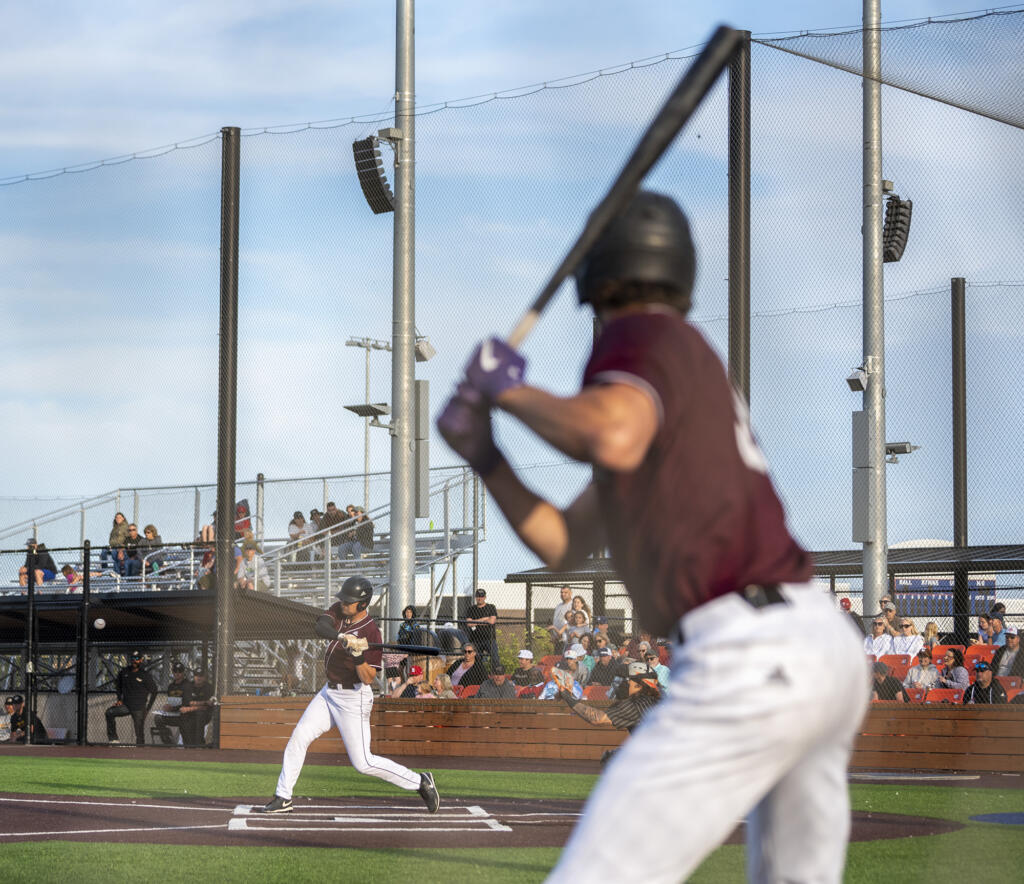 Raptors designated hitter Andy Allanson, left, swings at a pitch Tuesday, June 27, 2023, during the Raptors’ game against Bend at the Ridgefield Outdoor Recreation Complex.