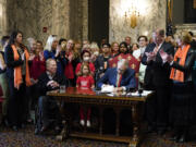 FILE - Washington Gov. Jay Inslee signs House Bill 1240, which prohibits the manufacture, importation, distribution and sale of semi-automatic assault-style weapons in the state, April 25, 2023, at the state Capitol in Olympia, Wash. A U.S. judge on Tuesday, June 6, rejected a request to block a new Washington state law banning the sale of certain semi-automatic rifles, one of three measures recently signed by Inslee in an effort to reduce gun violence.