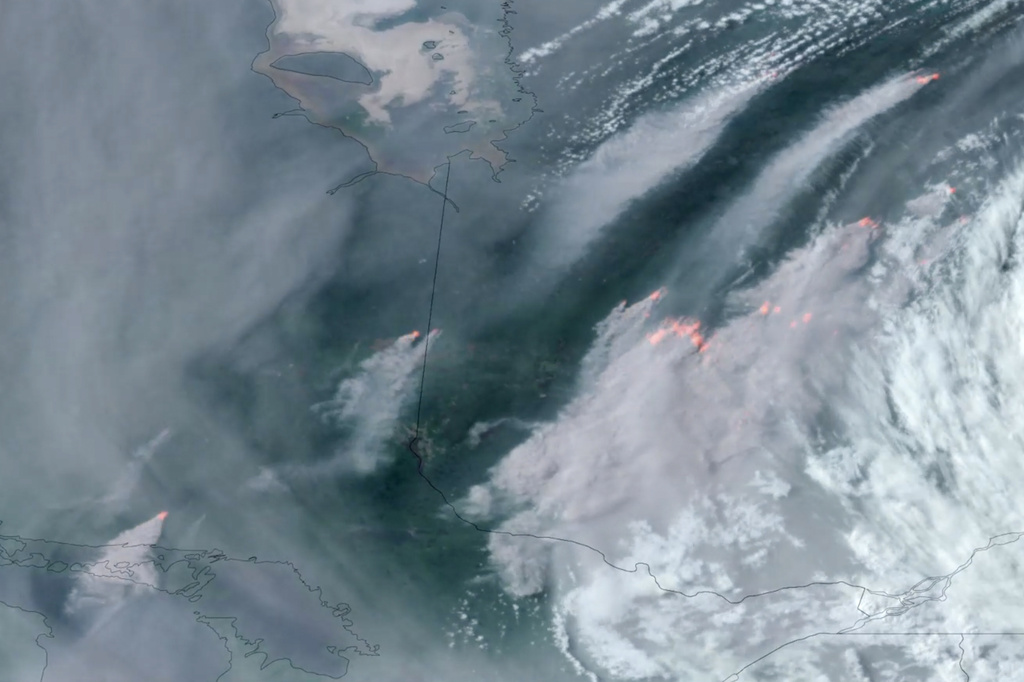 In this GOES-16 GeoColor and fire temperature satellite image taken Tuesday, June 6, 2023 at 6:40 p.m. EDT and provided by CIRA/NOAA, smoke from wildfires burning in the Canadian Provinces of Quebec, right, and Ontario, left, drift southward.