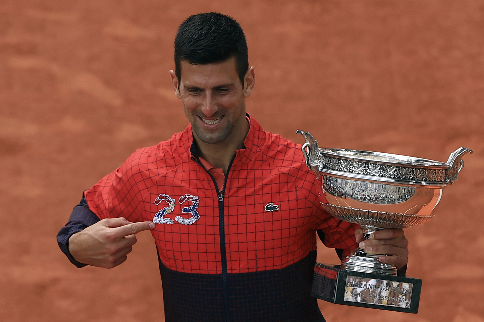 Serbia's Novak Djokovic holds the trophy as he celebrates winning the men's singles final match of the French Open tennis tournament against Norway's Casper Ruud in three sets, 7-6, (7-1), 6-3, 7-5, at the Roland Garros stadium in Paris, Sunday, June 11, 2023. Djokovic won his record 23rd Grand Slam singles title, breaking a tie with Rafael Nadal for the most by a man.