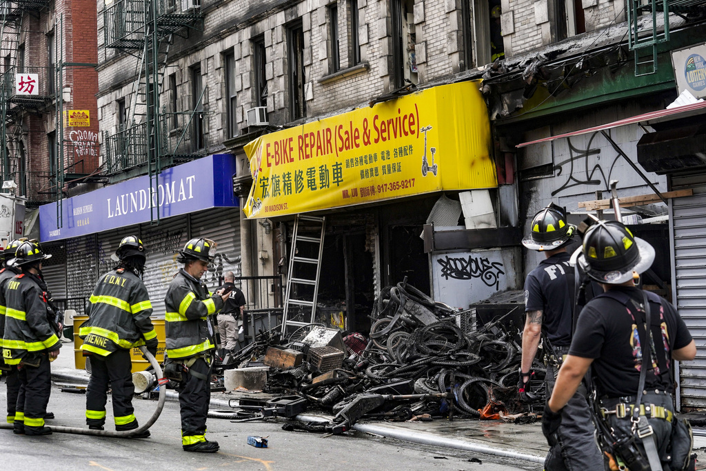 Firefighters and investigators go through the aftermath of a fire which authorities say started at an e-bike shop and spread to upper-floor apartments, Tuesday, June 20, 2023, in New York.